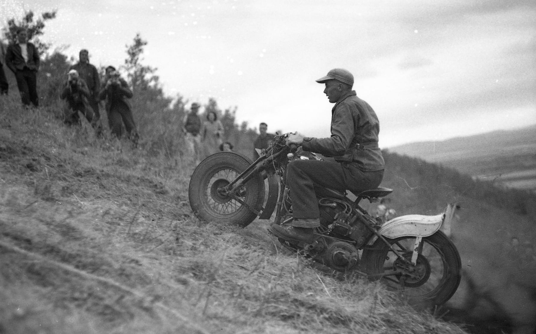 An Ace-Hy rider powers his motorcycle up the hill climb as the crowd looks on